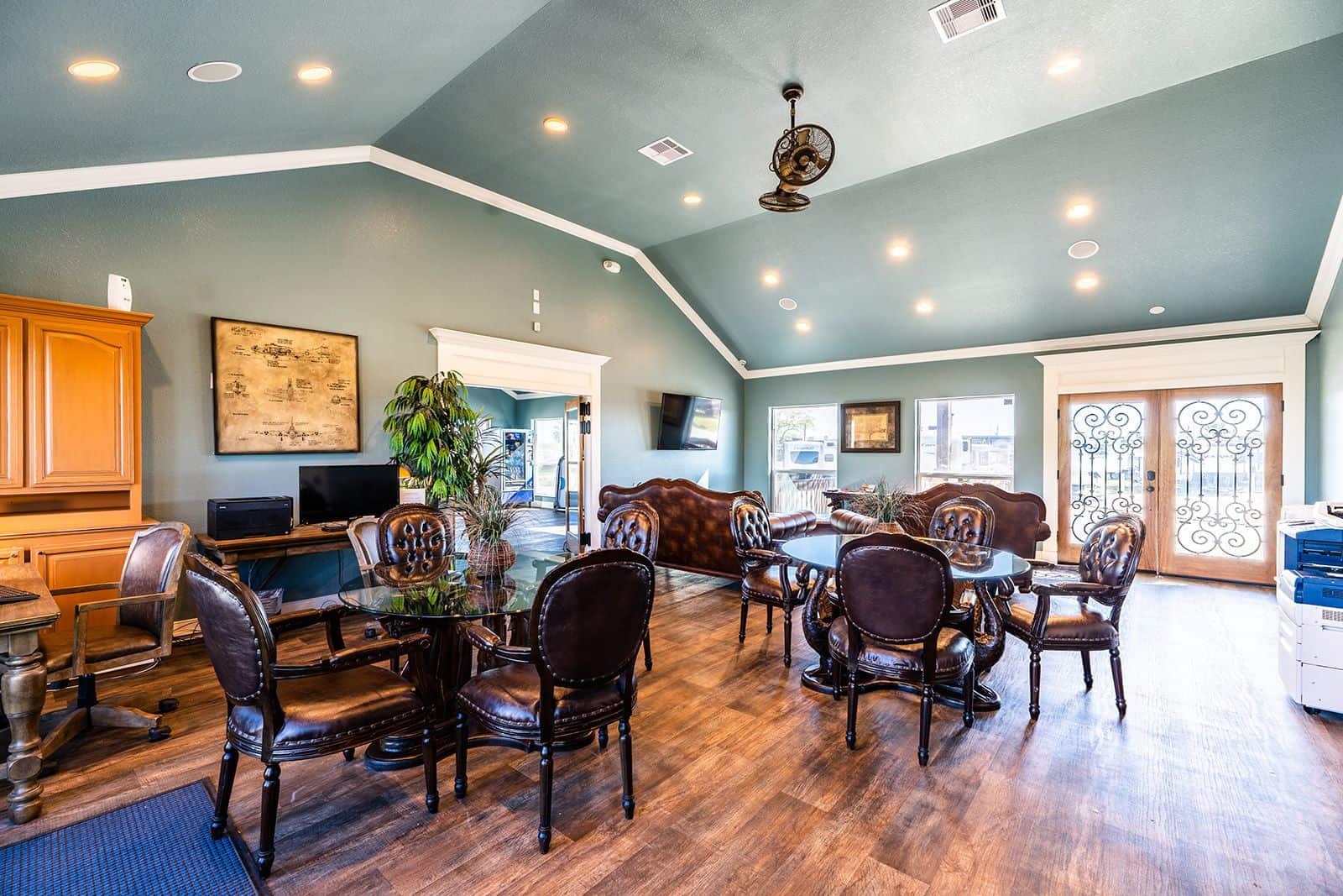 Clubhouse lounge with leather seating, TV, and wood floors