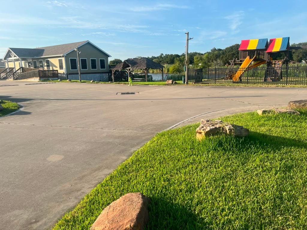 Resort grounds showing clubhouse, palapa pavilion, playground, and paved roads