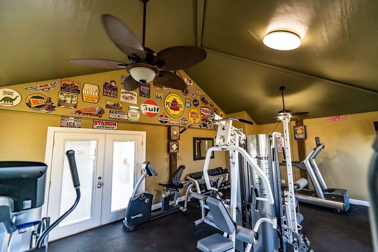 Fitness center with cardio machines, weight equipment, and vintage signage