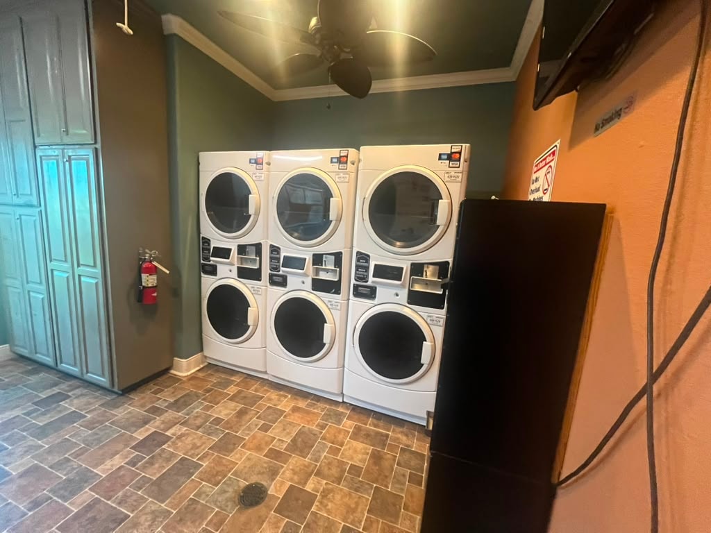 Laundry room with commercial front-load washers and dryers, tile floor, and ceiling fan
