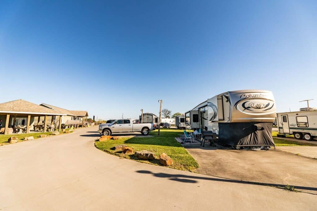 Concrete resort street with fifth-wheels and travel trailers parked along both sides