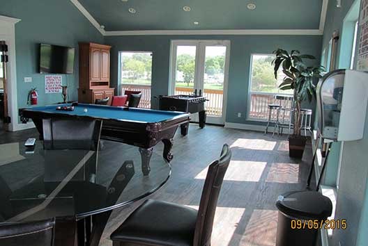 Clubhouse game room with pool table, foosball, and flat-screen TV