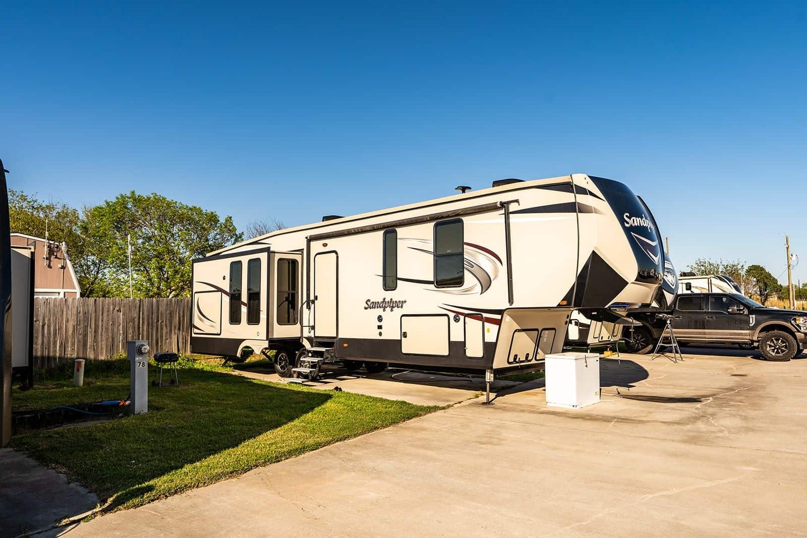 Sandpiper fifth-wheel on a full concrete pad at site 78 — Gulf Coast 5 Star RV Resort